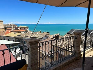 Un balcón con vista al mar y edificios.