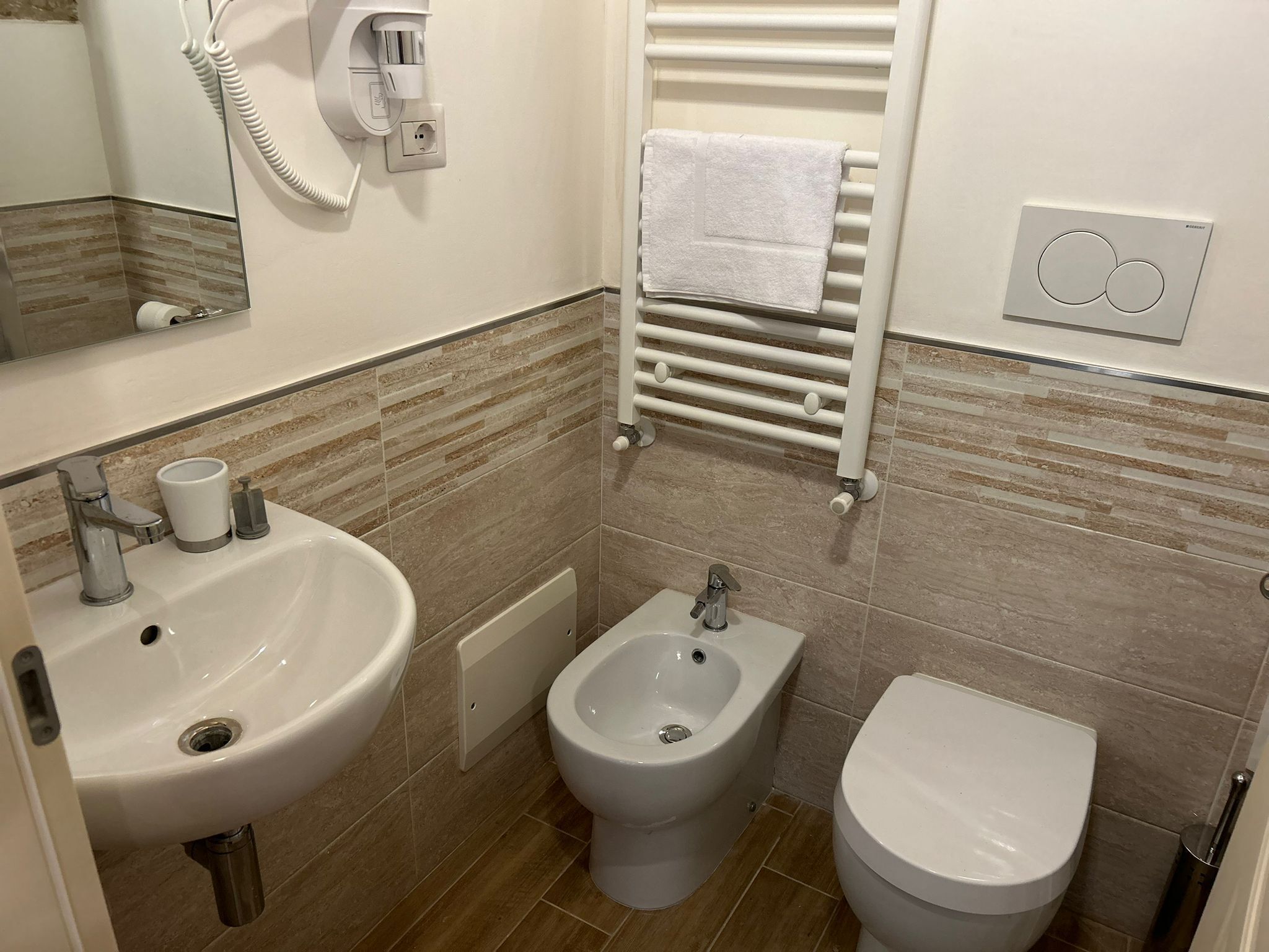 A bathroom with a sink, bidet, and toilet.