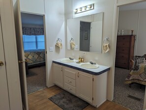 A bathroom with two sinks, a large mirror, and a vanity cabinet. - No Say Left Farm (Cofield)