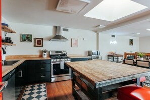 A modern kitchen with a central island, built-in oven, and stainless steel appliances.