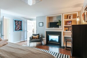 A modern living room with a fireplace, a sofa, and a television.