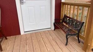 A wooden deck with a white door and a bench. - Something to Write Home About @ The Wild West 40  (Cane Beds)