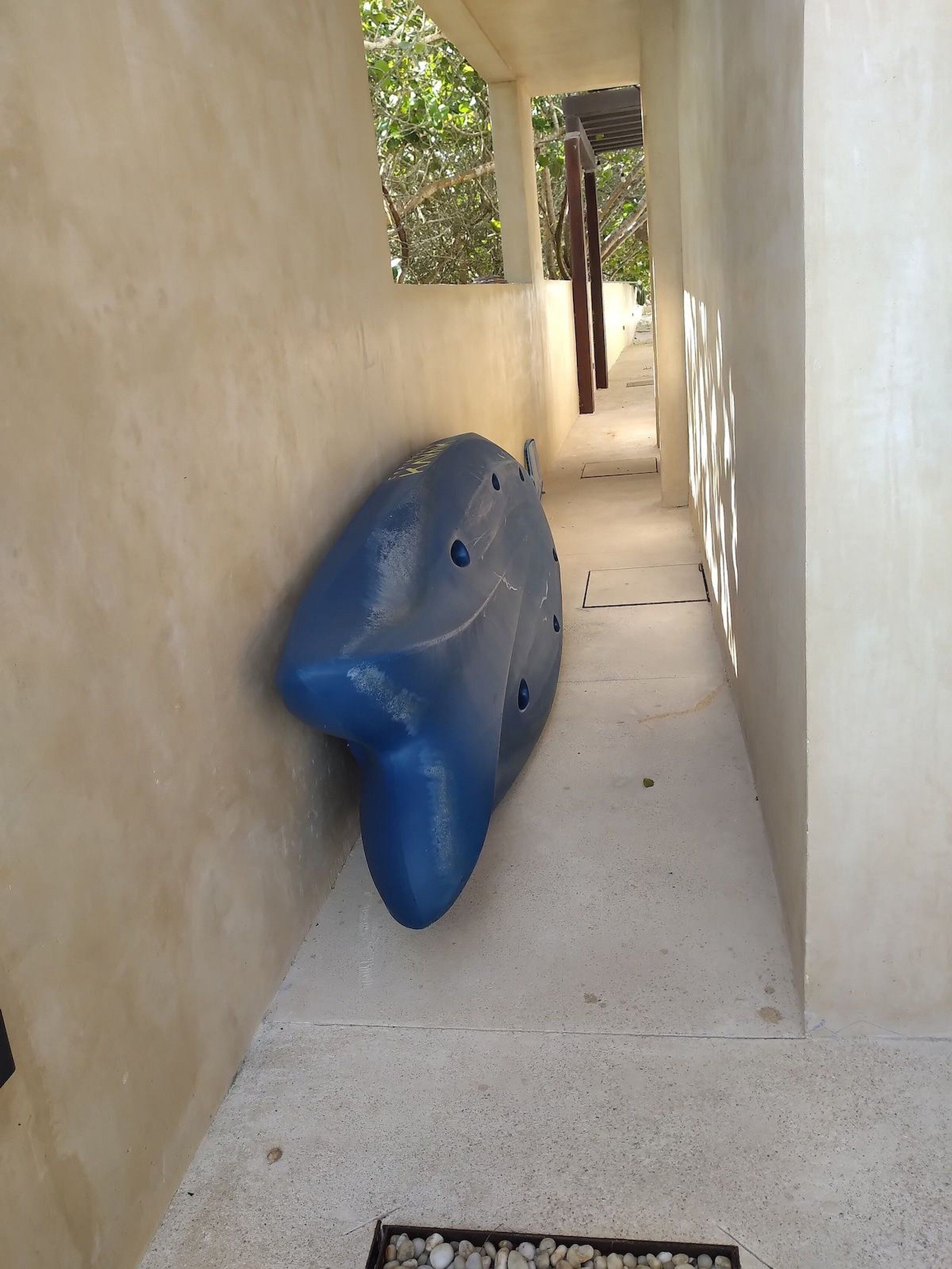 Ein Flur, in dem ein blaues Objekt an der Wand lehnt.
