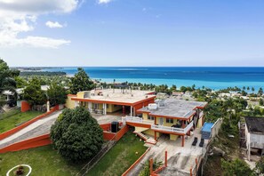 A coastal property with a large house, a swimming pool, and a view of the ocean. - 2 Villas, Tropical Oasis, Private Pool, Ocean View (Luquillo)