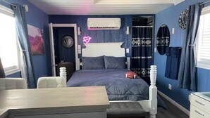 Un dormitorio con cama, mesitas de noche, escritorio y armario.
