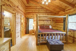 A wooden cabin bedroom with a four-poster bed, a wooden bench, and a small table with a bowl. - Sevierville Rental Cabin w/ Hot Tub & Game Room! (Sevierville)