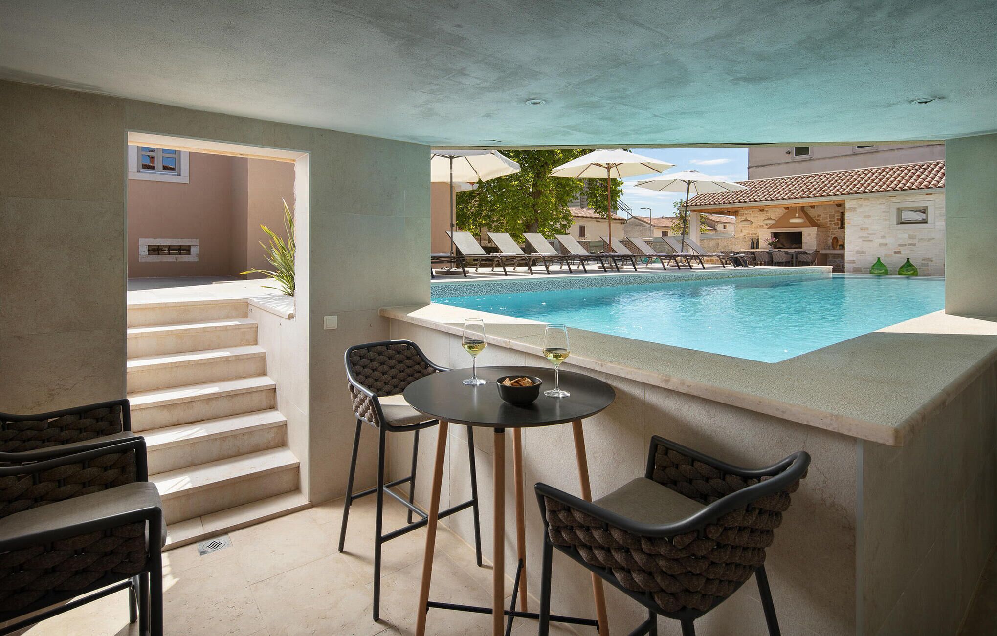 A poolside area with a bar, chairs, and a view of the pool.