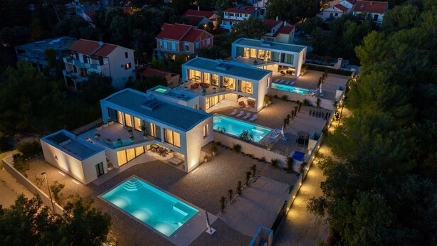 Un complejo residencial moderno con varias casas, una piscina y zonas de estar al aire libre.