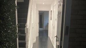 Um corredor com um tapete de entrada que diz 'NÃO É BEM-VINDO'.