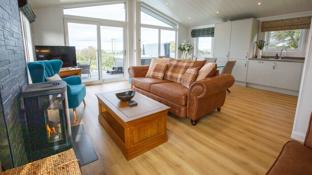 Ein gemütliches Wohnzimmer mit Kamin, einer Couch und einem Fernseher.