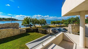 A modern building with a view of a lake and mountains. There are steps leading to a balcony with a railing. - 3 bedroom lovely home in Nin (Nin)