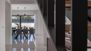 A modern interior with a dining area, staircase, and a view of the outdoors. - 4 bedroom awesome home in Sukosan (Sukosan)