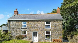 A stone house with a sloped roof, a front door, and multiple windows. - 2 bedroom accommodation in Troon, near Camborne (Troon, near Camborne)