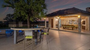 Une terrasse extérieure avec une piscine, un espace salon et un bâtiment en pierre dont l’intérieur est revêtu de carreaux.