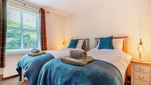 A double bed with a wooden headboard, two bedside tables, and a nightstand with a lamp. - 3 bedroom accommodation in Fir Tree, near Crook (Fir Tree, near Crook)