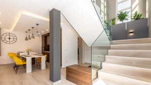 Un interior moderno con escalera, comedor y cocina.