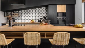 A modern kitchen with a central island, black cabinetry, and a backsplash with a star pattern. - 3 bedroom awesome home in Krsan (Krsan)