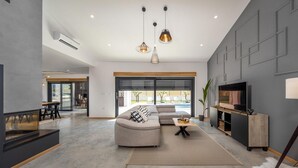 A modern living room with a grey sectional sofa, a TV, and a fireplace. - 3 bedroom awesome home in Krsan (Krsan)