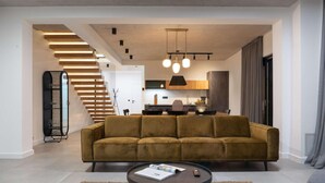 Una sala moderna con un sofá, una mesa de centro y una escalera.