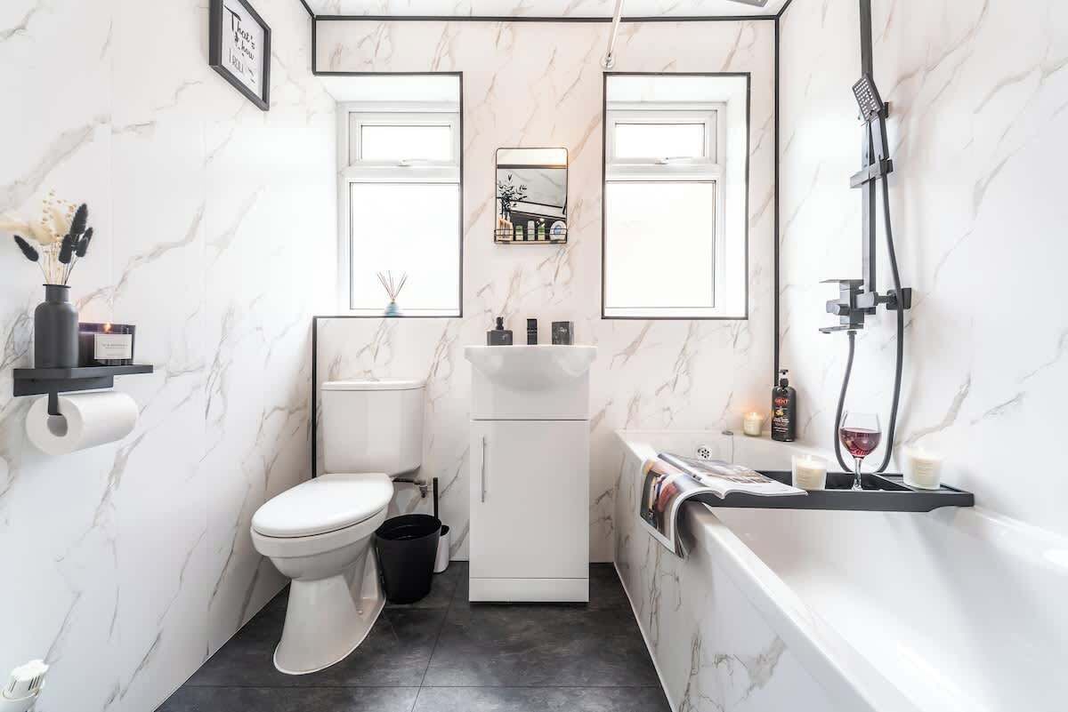 Een kleine badkamer met toilet, wastafel en douche.