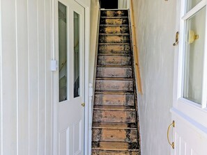 A staircase with wooden steps leading to a landing, flanked by white doors with glass panels. - 1 bedroom accommodation in Tremadog, near Porthmadog (Tremadog, near Porthmadog)