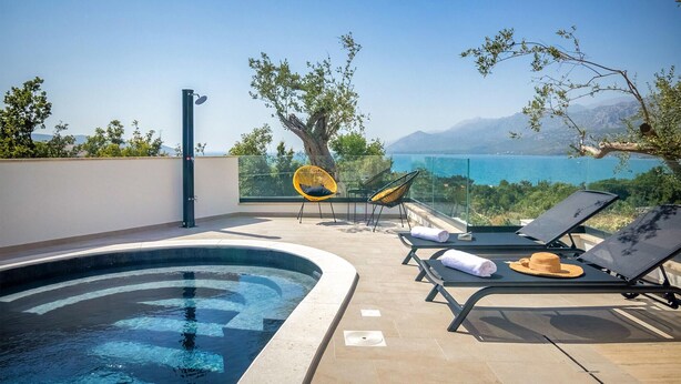 A rooftop pool area with lounge chairs, a glass balustrade, and a view of the sea and mountains. - Stunning home in Rovanjska with sauna (Rovanjska)