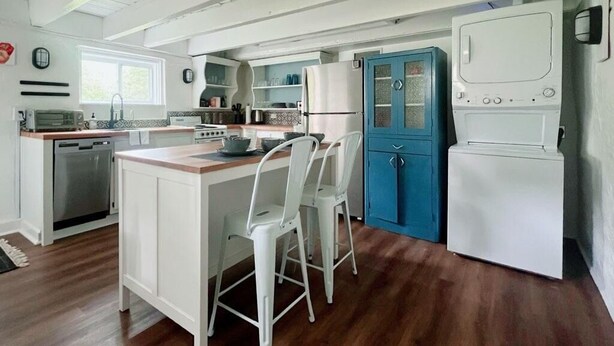 A compact kitchen with white cabinetry, a blue door, and a white refrigerator. - Hometract Cottage, Historic Property, UVA/Charlottesville/Ivy (Charlottesville)