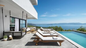 A modern outdoor pool area with lounge chairs and a view of the sea. - Luxurious home in Crni (Crni)