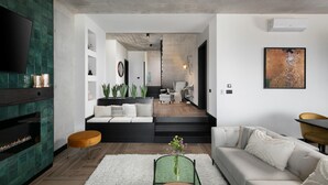 A modern living room with a fireplace, a sofa, a coffee table, and a TV. - Luxurious home in Crni (Crni)