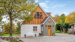 A rustic cabin with a wooden exterior, a white exterior wall, and a gravel driveway. - 2 bedroom accommodation in Foxhole, near Beauly (Foxhole, near Beauly)