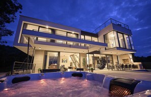 Ett modernt hus i två våningar med ett bubbelbadkar som syns tydligt på framsidan.