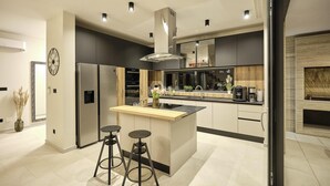 Una cocina moderna con una isla central, electrodomésticos integrados y un amplio ventanal.