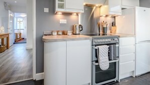 A modern kitchen with white cabinetry, a stainless steel range hood, and a built-in oven. - 2 bedroom accommodation in Southbourne, near Bournemouth (Southbourne, near Bournemouth)