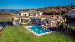 A large two-story house with a swimming pool, a covered patio, and a view of the surrounding landscape. - Luxurious home in Bajkini (Bajkini)