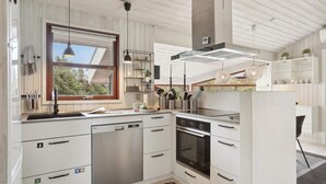 A modern kitchen with white cabinetry, a built-in oven, and a large window providing natural light. - Cozy home in Hjørring with WiFi (Hjørring)