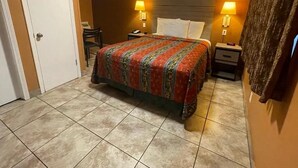 Een hotelkamer met een groot bed, twee nachtkastjes en twee wandlampen.