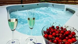 Ein Whirlpool mit zwei Sektgläsern und einer Schale Kirschen.