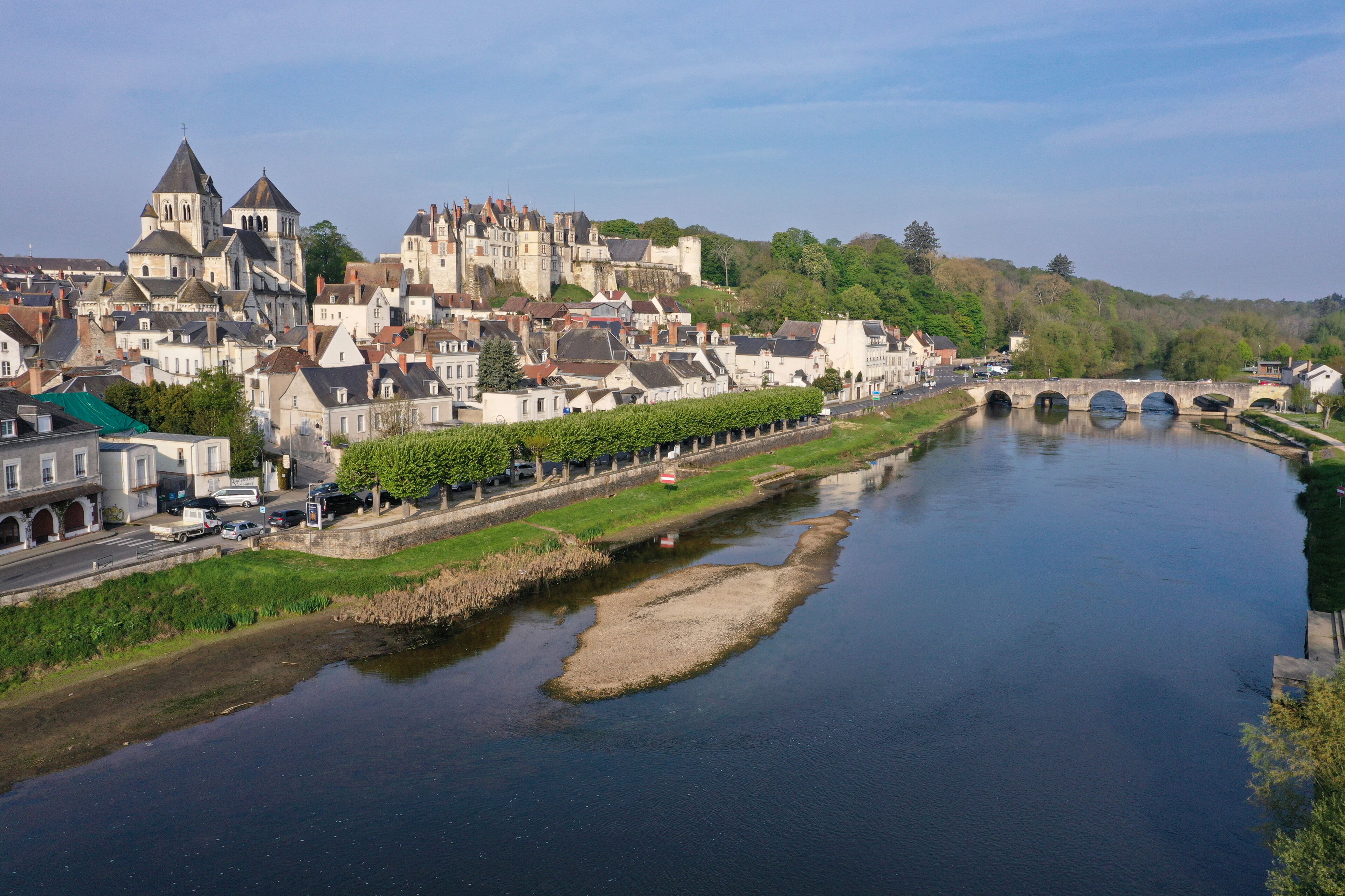 Ein Fluss fließt durch eine Stadt mit historischen Gebäuden und einer Brücke.