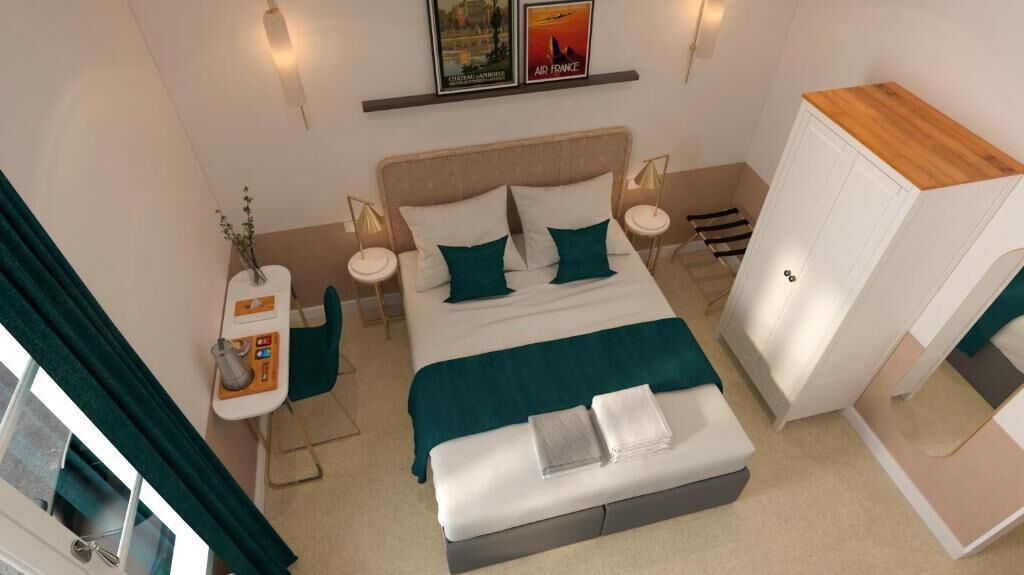 A modern hotel room with a bed, bedside tables, a desk, and a wardrobe.