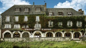 Un bâtiment historique portant une enseigne indiquant « GRAND HÔTEL S’AIGNAN » et « RESTAURANT », ce qui indique qu’il s’agit d’un hôtel et d’un restaurant.