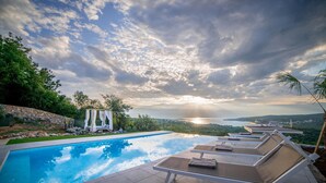 A swimming pool with lounge chairs and a canopy, overlooking a scenic landscape with a sunset. - Beautiful home in Suzan (Suzan)