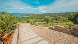 A stone pathway leading to a scenic overlook with a view of a coastal landscape and distant hills. - Beautiful home in Suzan (Suzan)