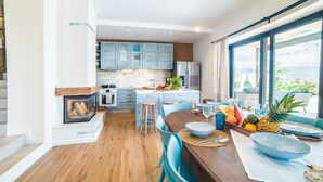 A modern kitchen with a central island, wooden flooring, and a view of the outdoors. - Beautiful home in Suzan (Suzan)