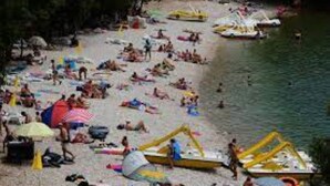 A crowded beach with people sunbathing and swimming, and several boats anchored nearby. - Beautiful new Villa with private pool ideal for vacation for couples or a family (Krnica)