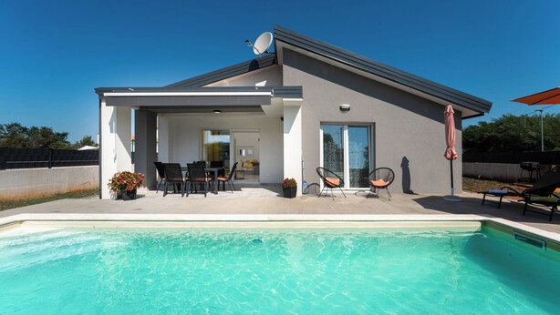 A modern house with a swimming pool, outdoor seating, and a satellite dish. - Beautiful new Villa with private pool ideal for vacation for couples or a family (Krnica)