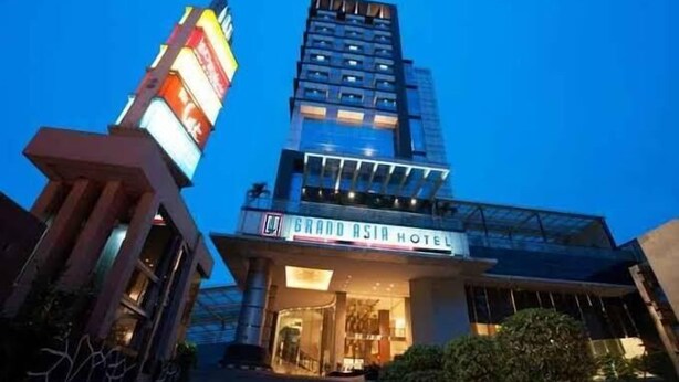 Un hôtel moderne avec une enseigne bien visible indiquant « Grand Asia Hotel ».