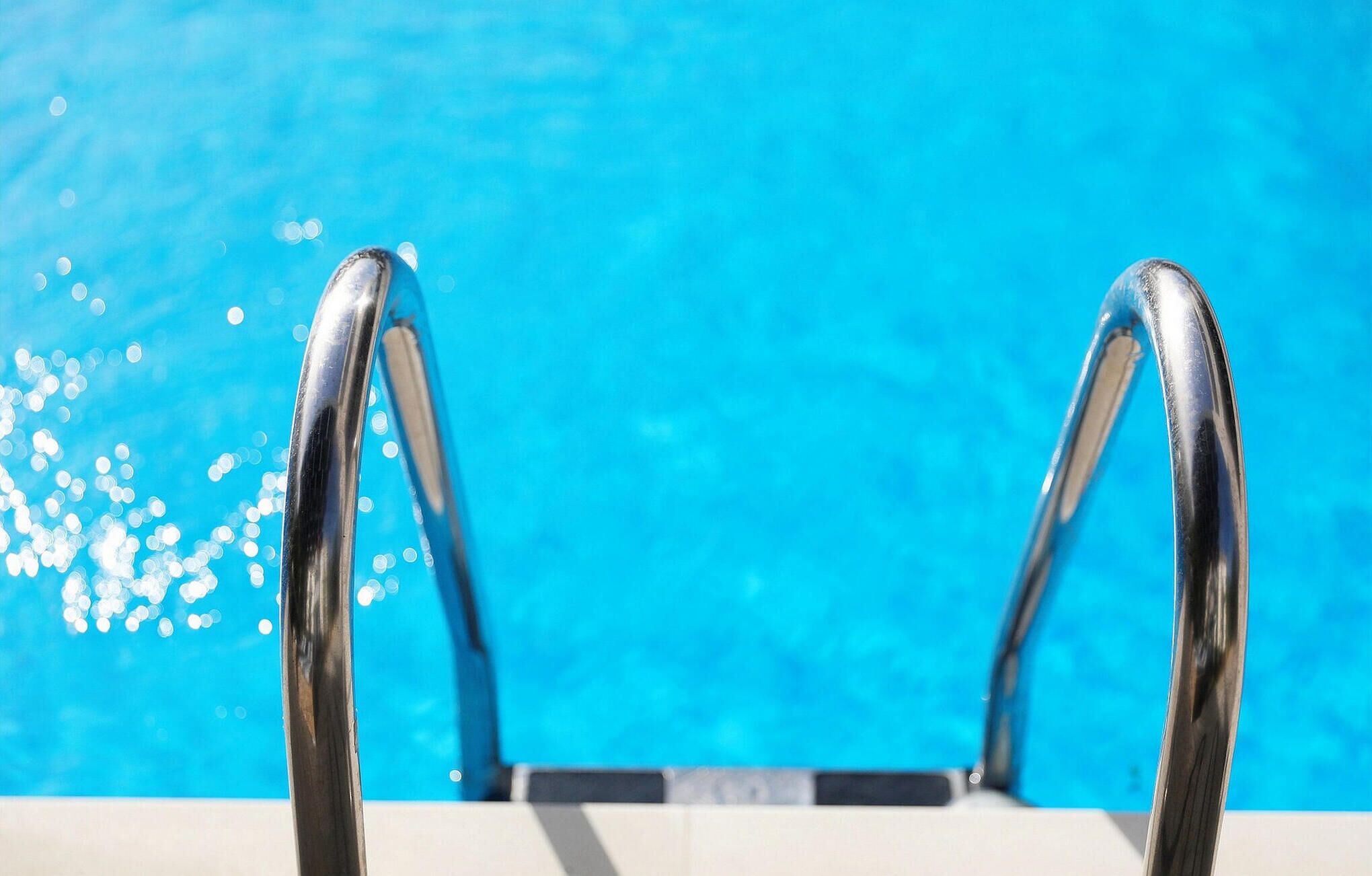 Piscina com corrimãos de metal.