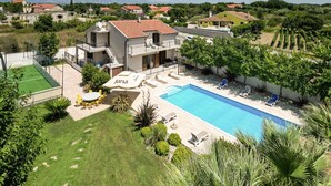 A villa with a swimming pool, outdoor seating, and a tennis court. - Lovely home in Policnik with sauna (Policnik)