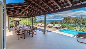 An outdoor patio with a pool, dining area, and lounge chairs. - Beautiful home in Mirca (Mirca)