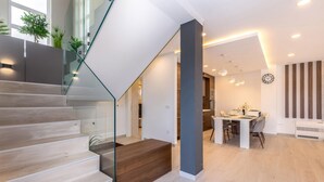 Ein modernes Interieur mit Treppe, Essbereich und Küche.